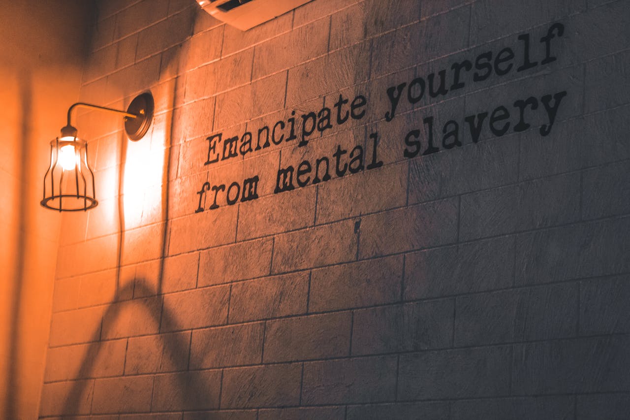Services-02 A wall lamp casts a warm glow on an inspirational quote about mental freedom.